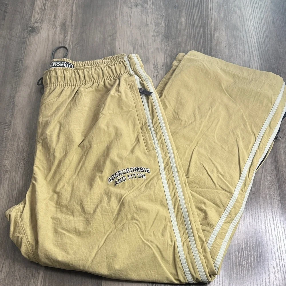 Vintage 90’s  Y2K Abercrombie and Fitch tan track pants with white stripes.